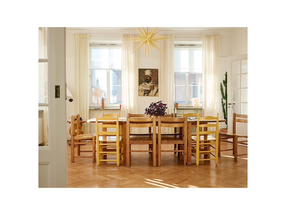 Matsalen hemma hos Emma och Saif, med höga fönster samt bord och stolar i massivt trä.